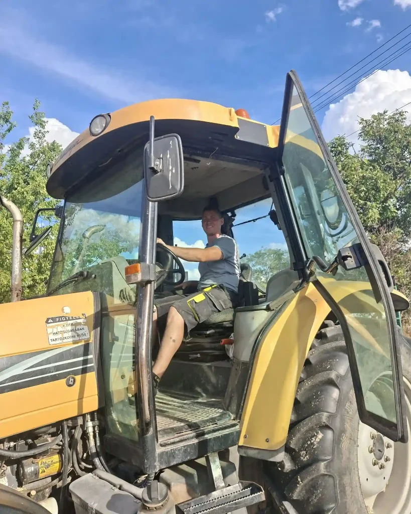 Férfi egy sárga traktor vezetőfülkéjében a Zsemberi Tanyán